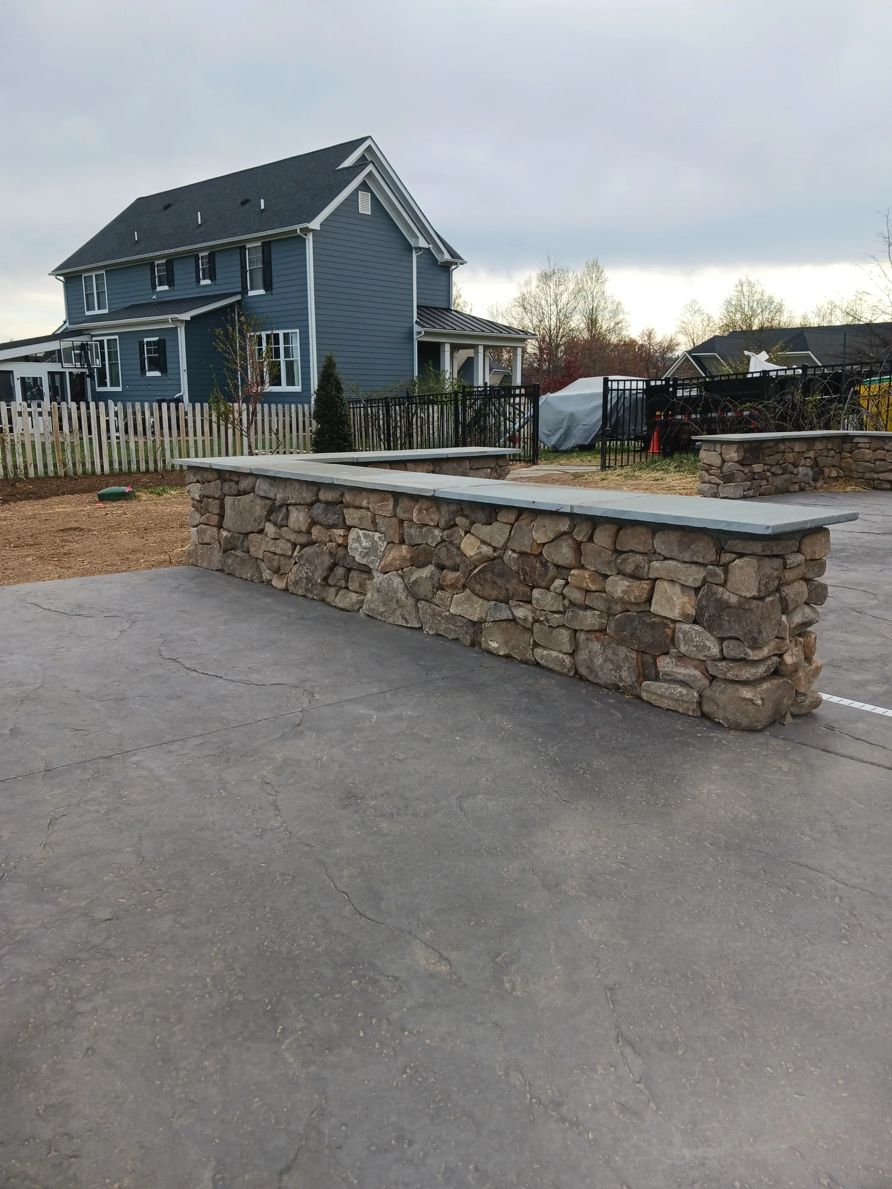 Stone patio and low wall beside a home