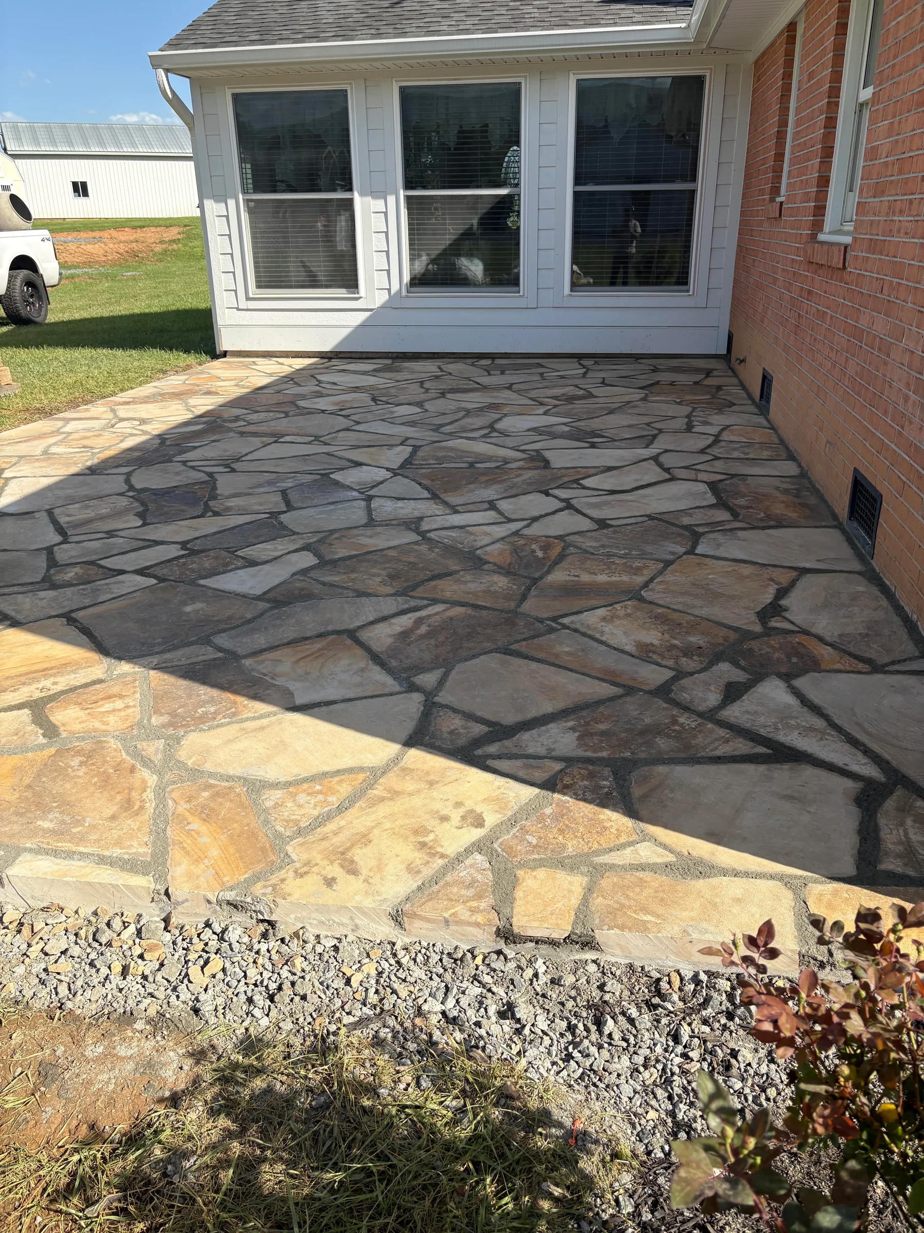 Flagstone patio beside a sunroom