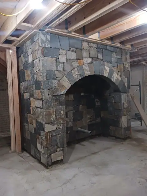 Arched stone fireplace during interior construction