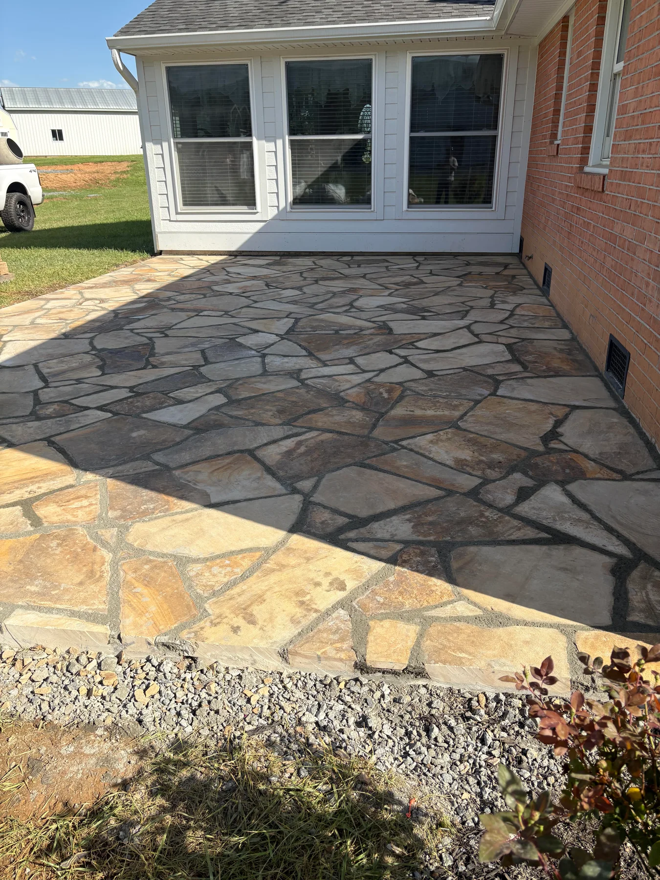 Flagstone patio beside a sunroom