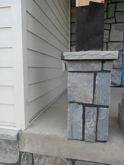 Completed stone column beside home siding
