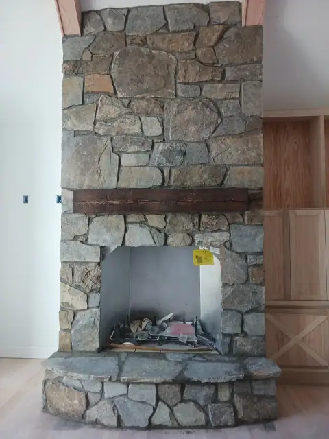 Indoor stone fireplace under construction with exposed opening