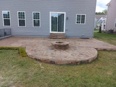 Outdoor stone fire pit and patio by F. Stone Designs