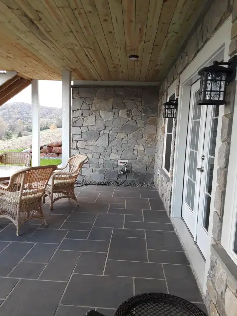 Covered patio with stone flooring and stone-clad walls