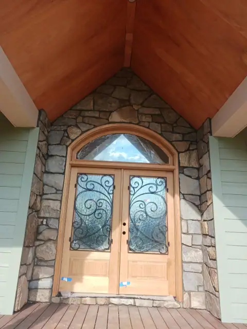 Stone entrance with arched wood doorway