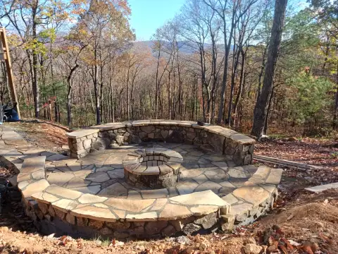 Outdoor stone fire pit and patio by F. Stone Designs