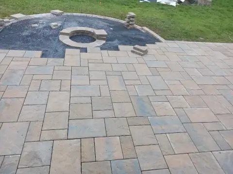 Outdoor stone fire pit and patio by F. Stone Designs