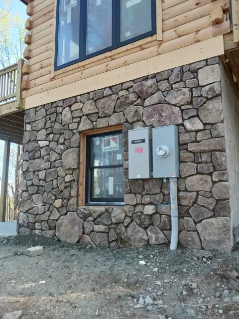 Natural stone foundation wall with utility connections