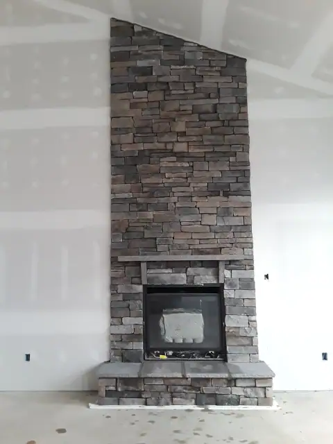 Indoor natural stone fireplace by F. Stone Designs