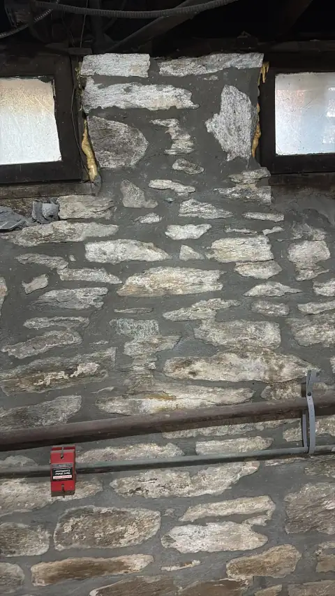 Repaired stone foundation wall with fresh mortar joints