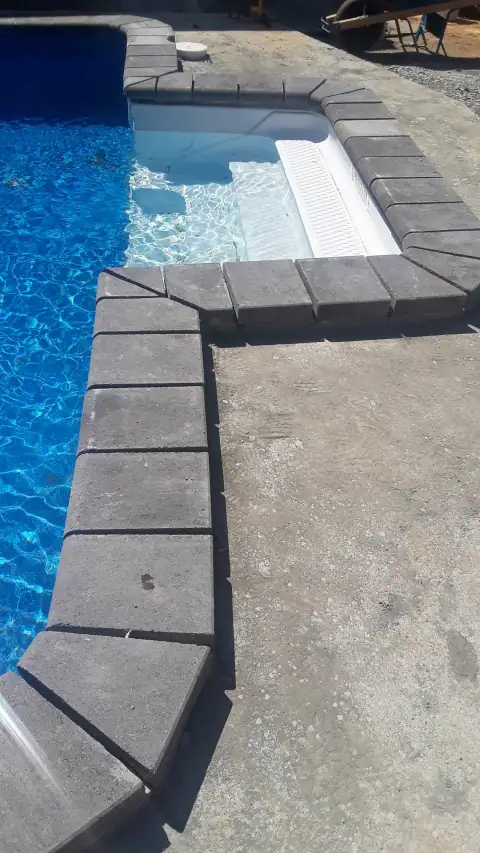 Completed pool coping and stone pool deck corner