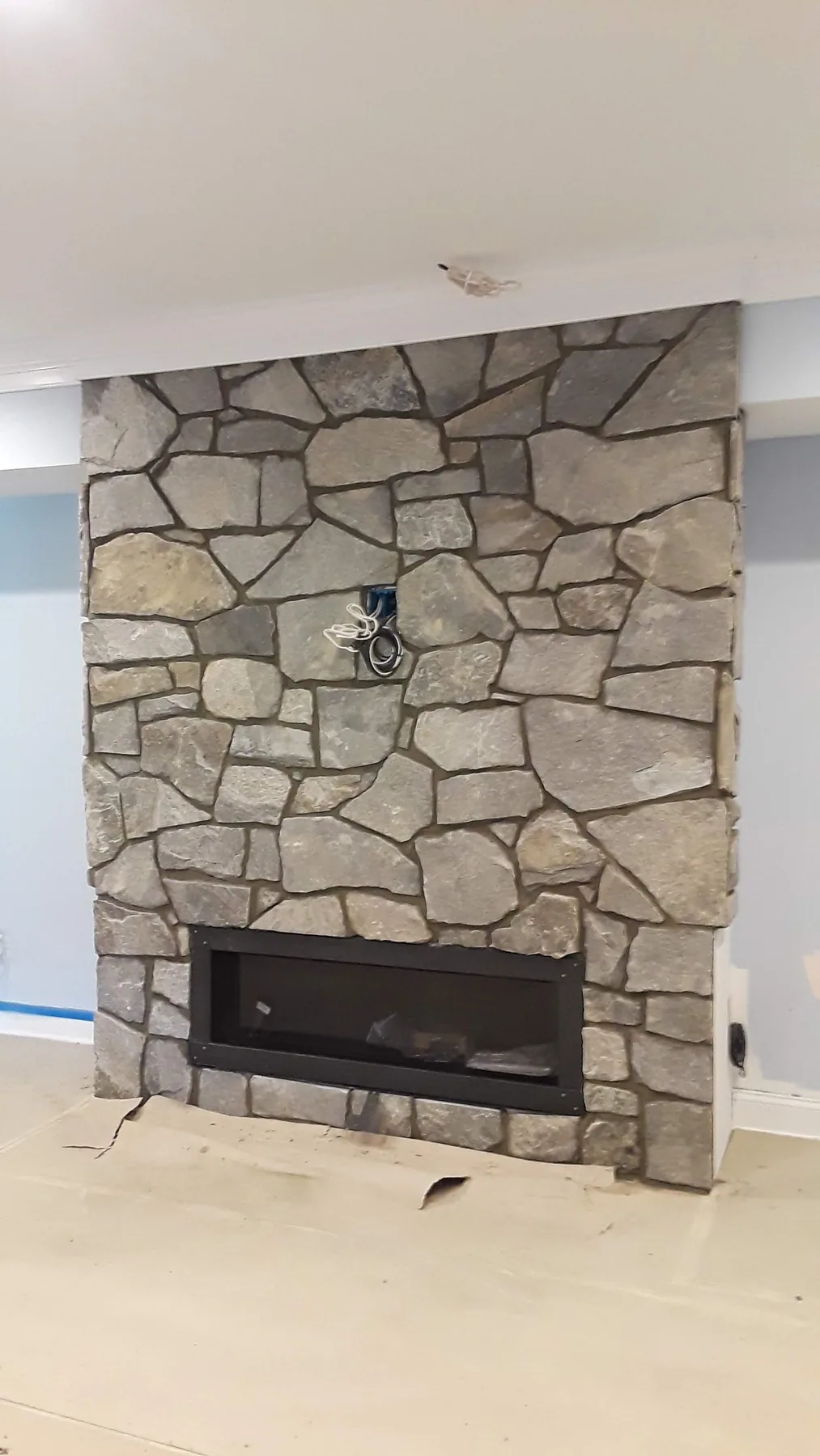 Floor-to-ceiling natural stone fireplace in a living room