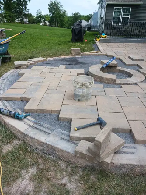 Outdoor stone fire pit and patio by F. Stone Designs
