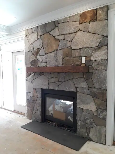 Indoor natural stone fireplace by F. Stone Designs